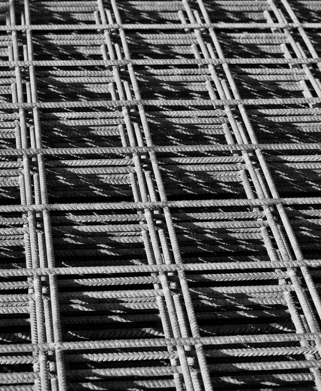 Sheets of welded reinforcing mesh casting hard shadows in the sun